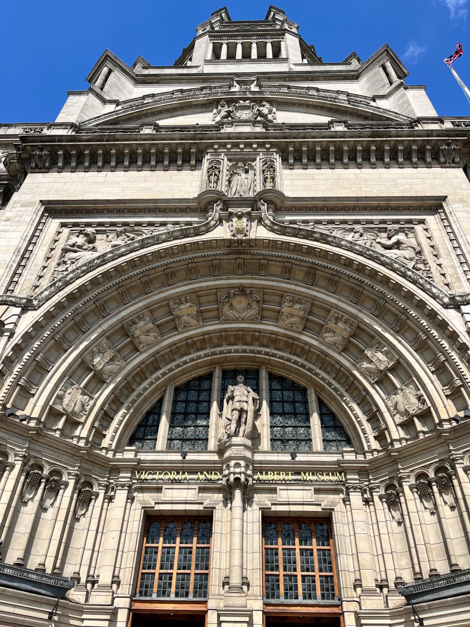 Ornate stone entrance to the Victoria and Albert Museum beneath a blue sky