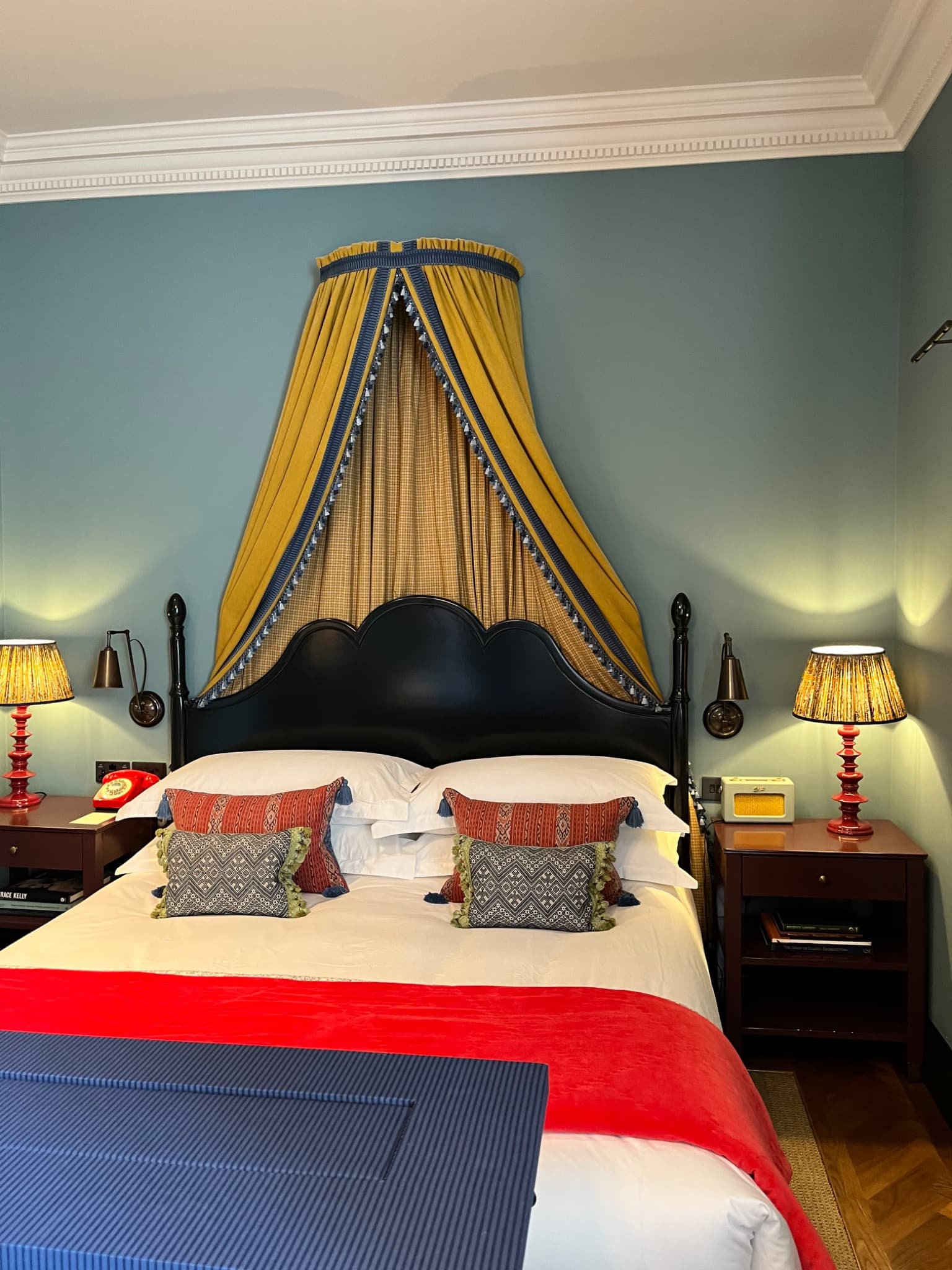 Bedroom at Beaverbrook Town House with a yellow canopy and red bedspread
