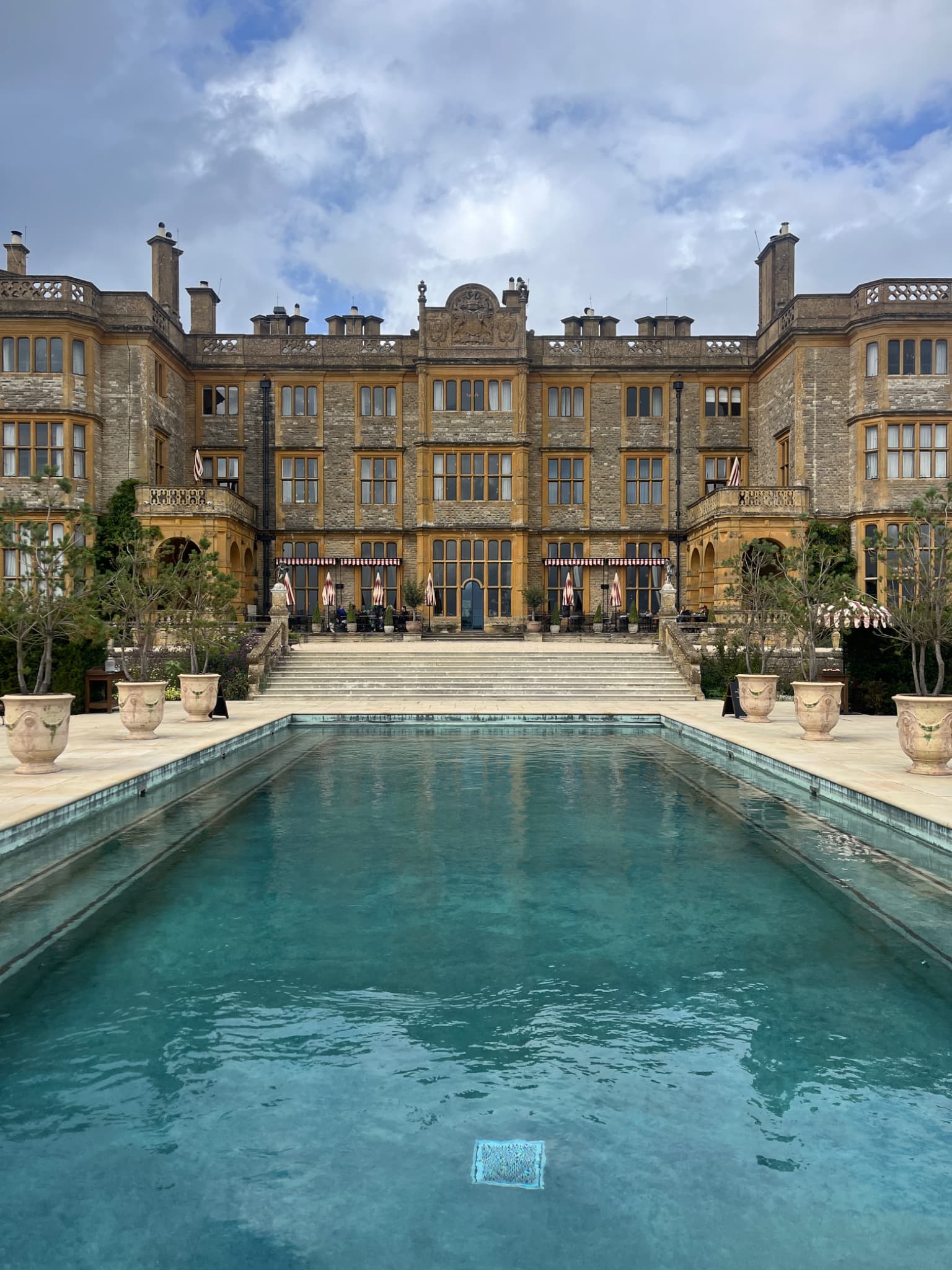 Estelle Manor’s stone façade and terrace viewed across the outdoor swimming pool