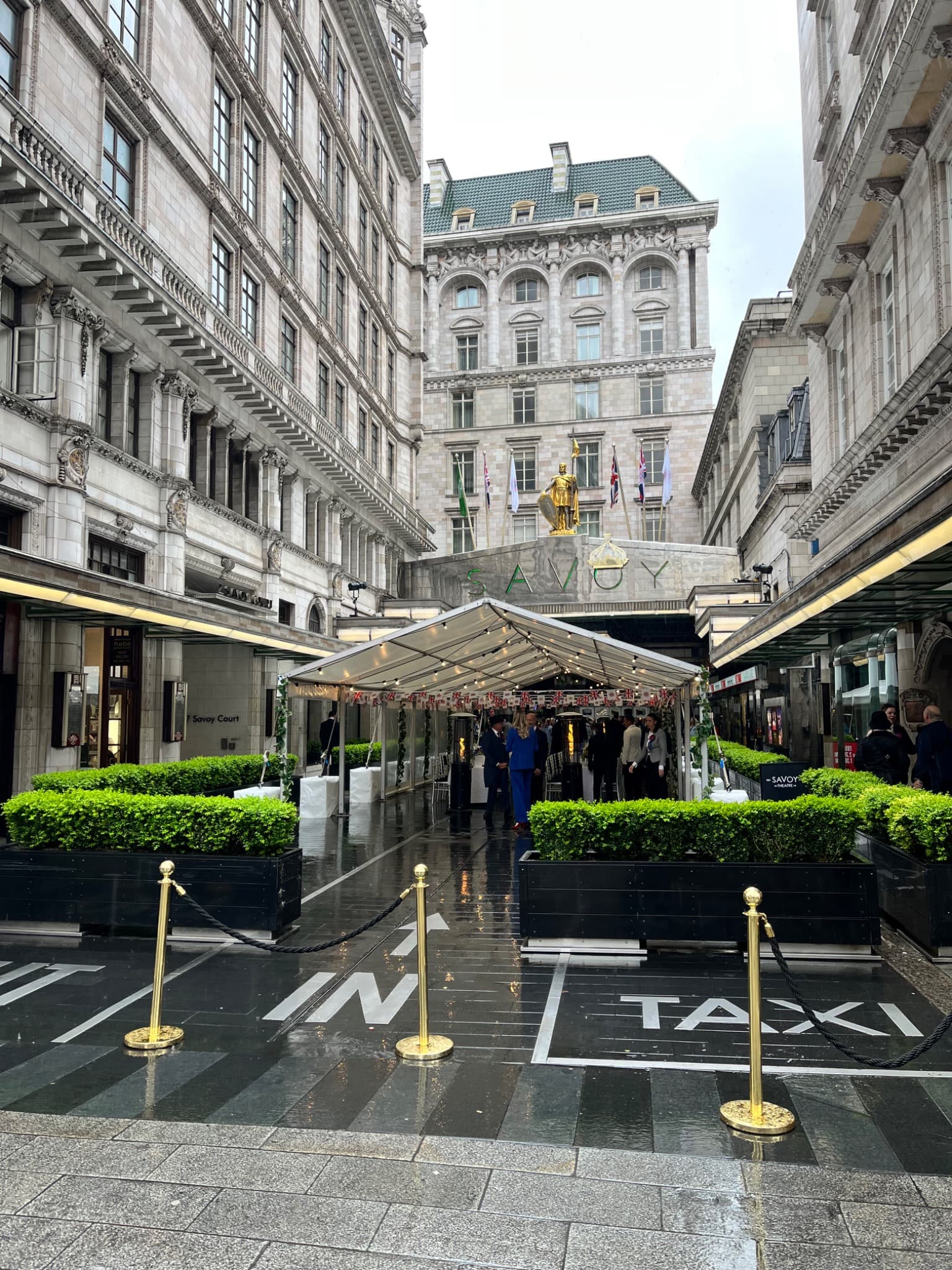 The Savoy entrance and hotel façade viewed from Savoy Court, with the Savoy sign and golden statue above the canopy